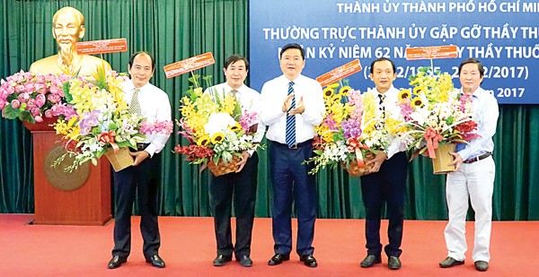 Party Chief Thang (center) gives flowers to congratulate four medical workers who are entitled People's Doctors (Photo: SGGP) Party Chief Thang (center) gives flowers to congratulate four medical workers who are entitled People's Doctors (Photo: SGGP)
